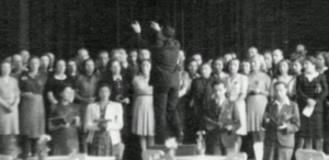 The only known photo of Theresienstadt inmates performing Verdi’s Requiem Mass, taken during the final performance on June 23, 1944. Raphael ‘Rafi’ Schachter is seen conducting the choir, with Adolf Eichmann and an International Red Cross delegation in the audience (courtesy: The Terezin Foundation)