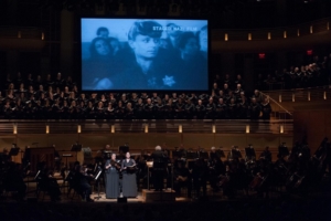 Soloists perform as footage from a Nazi propaganda film is shown during a 2014 performance of Defiant Requiem. (Photo credit: Randy Sager)